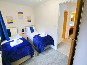 ein Hotelzimmer mit 2 Betten und einem Spiegel in der Unterkunft Pass the Keys King Bed Family Home With Parking WM Discounts in Manchester
