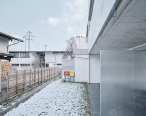 einen schneebedeckten Bürgersteig neben einem weißen Gebäude in der Unterkunft Wohnen in Wattens Top 3 in Wattens