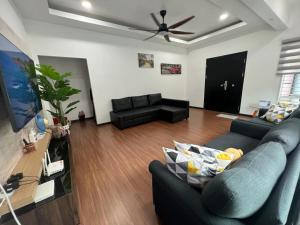 a living room with a couch and a ceiling fan at Homestay with pool kuantan in Kuantan