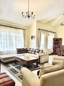 a living room with couches and a table at Westlands Escape-Homestay in Nairobi