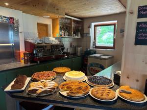 een bar met veel verschillende soorten taarten en gebak bij Hotel Ristorante Lagrev in Maloja