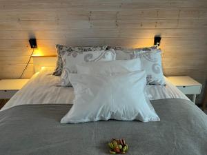 a white bed with white pillows and fruit on it at Beachboog LAHEMAA in Kuusalu