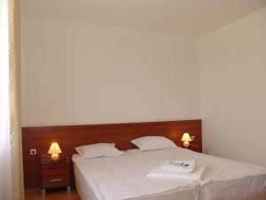 1 dormitorio con 1 cama con 2 almohadas blancas en Apart Hotel Kasandra, en Sunny Beach