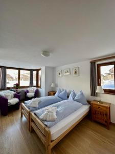 a bedroom with a large bed and a couch at Hotel Ristorante Lagrev in Maloja