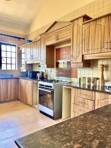 a large kitchen with wooden cabinets and a stove at Westlands Escape-Homestay in Nairobi