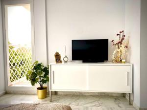 een wit entertainmentcentrum met een televisie erop bij MyChoice Casa Milán by Bossh! Apartments in Rota