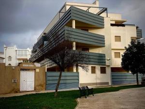 een gebouw met een bank ervoor bij MyChoice Casa Milán by Bossh! Apartments in Rota
