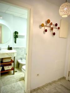 een badkamer met een wastafel, een toilet en een spiegel bij MyChoice Casa Milán by Bossh! Apartments in Rota