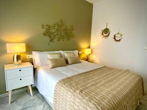 een slaapkamer met een bed en een nachtkastje met 2 lampen bij MyChoice Casa Milán by Bossh! Apartments in Rota