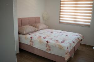 a bedroom with a bed with a floral bedspread at Apartmani ELEGANCE Tuzla in Tuzla