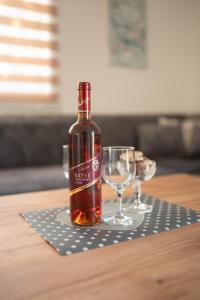 - une bouteille de vin et deux verres sur une table dans l'établissement Apartmani ELEGANCE Tuzla, à Tuzla