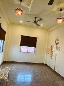 an empty room with a ceiling fan and a window at Kashi Village Home Stay in Varanasi