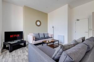 uma sala de estar com um sofá e uma mesa em Apartment No 2 At Empire 39 em Scarborough