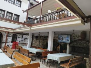 a restaurant with tables and chairs and a balcony at Hotel Bolyarka in Melnik
