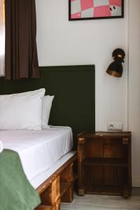 a bedroom with a bed and a table with a lamp at Limon Inn Hotel, Taşucu in Tasucu