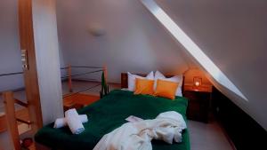 a bedroom with a green bed in a attic at Apartament Pod 12 B in Bielsko-Biała