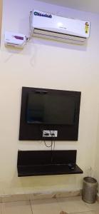TV de pantalla plana en la pared en Hotel Amar Inn, en Jalandhar