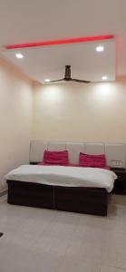 Cama en habitación con 2 almohadas rojas en Hotel Amar Inn, en Jalandhar