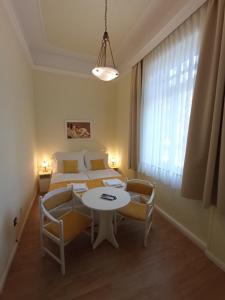 a bedroom with a bed and a table with chairs at Apartman Orgona in Siófok