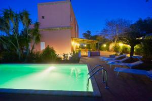 a swimming pool in front of a building at night at Villa Maria in Marsala