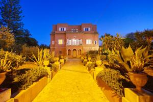 a large house with a bunch of potted plants at Villa Maria in Marsala