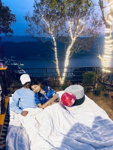 a man and a woman laying on a large bed at (Sab’s villa )Forest cabin in Pokhara