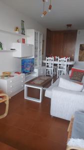 a living room with white furniture and a table at Estupendo apartamento en San Vicente do Mar O Grove in San Vicente do Mar
