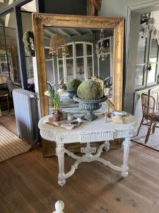 a table in front of a mirror with a vase at Maison de Vacances avec Piscine Privée en Dordogne in Boisse