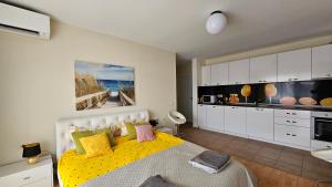 a bedroom with a yellow bed and a kitchen at 2 Zimmer Wohnung in Sunny Beach