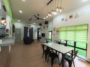 ein Esszimmer und ein Wohnzimmer mit einem Tisch und Stühlen in der Unterkunft A’famosa Moments villa 924 covered Bbq KTV pool in Kampong Alor Gajah