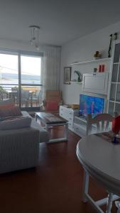a living room with a couch and a tv at Estupendo apartamento en San Vicente do Mar O Grove in San Vicente do Mar
