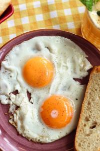 two eggs on a plate with a slice of bread at Limon Inn Hotel, Taşucu in Tasucu
