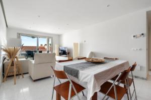 eine Küche und ein Wohnzimmer mit einem Tisch und Stühlen in der Unterkunft Apartamento WELCS PDA -114- en el puerto con piscina in Platja  d'Aro
