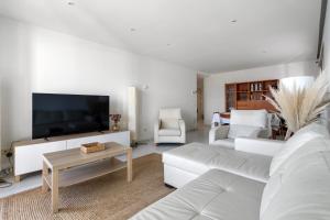 ein Wohnzimmer mit einem weißen Sofa und einem TV in der Unterkunft Apartamento WELCS PDA -114- en el puerto con piscina in Platja  d'Aro