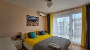 a bedroom with a yellow bed and a window at 2 Zimmer Wohnung in Sunny Beach +8 photos