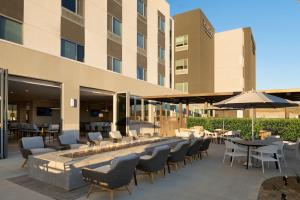 d'une terrasse avec des tables, des chaises et un foyer extérieur. dans l'établissement TownePlace Suites by Marriott Marriott Barstow, à Barstow