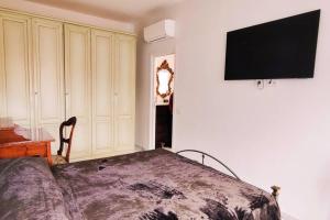 een slaapkamer met een bed en een televisie aan de muur bij Arcole Deluxe in Napels