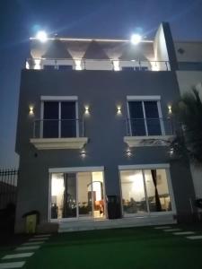 a white house with lights on it at night at درة العروس - فيلا الحلم Dream 4u in Durat Alarous