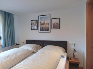 two beds in a bedroom with pictures on the wall at Apartment Sonnenwinkl in Kössen