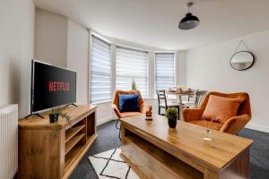 a living room with a television and a table at Queens Cabin - Near South Bay Beach in Scarborough