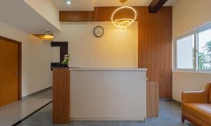 um átrio de escritório com um balcão e um relógio na parede em Itsy By Treebo - Avani Stays - Vyttila, Kochi em Ernakulam