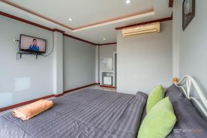 1 dormitorio con 1 cama y TV en la pared en PloyPhailin พลอยไพรินรีสอร์ท, en Koh Larn