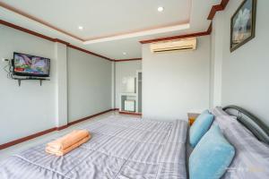 ein Schlafzimmer mit einem Bett und einem TV an der Wand in der Unterkunft PloyPhailin พลอยไพรินรีสอร์ท in Ko Larn