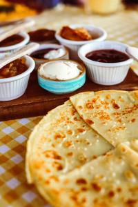 a wooden table with a pizza and bowls of dips at Limon Inn Hotel, Taşucu in Tasucu