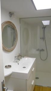 a white bathroom with a sink and a mirror at LE REGRATTIER ST LOUIS in Paris
