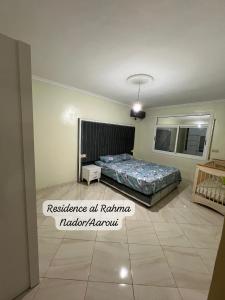 - une chambre avec un lit et un miroir dans l'établissement Residence al Rahma nr 01, à Monte ʼArrouit