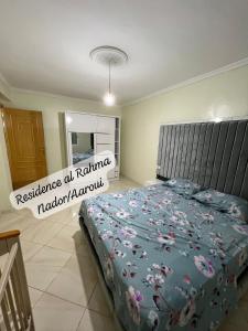 een slaapkamer met een bed met een blauw dekbed bij Residence al Rahma nr 01 in Monte ʼArrouit