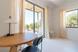 a dining room with a table and a large window at Casale Valverde in Alghero