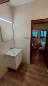 ein Bad mit einem Waschbecken und einem Wandspiegel in der Unterkunft Apartmán Stodola in Malá Morávka