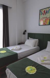 two beds in a room with green and white at Limon Inn Hotel, Taşucu in Tasucu